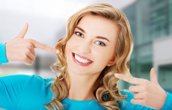 smiling woman pointing at her teeth
