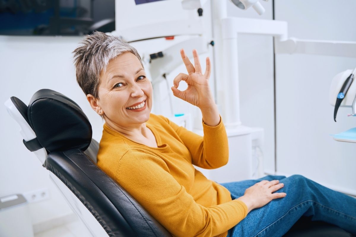 happy patient siting at dental office after crowns consultation in Sugar Land