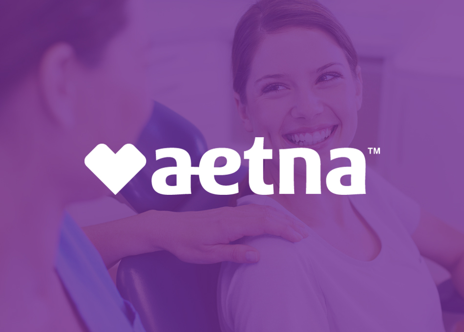 Aetna logo displayed over purple-toned background with smiling healthcare professional in scrubs.
