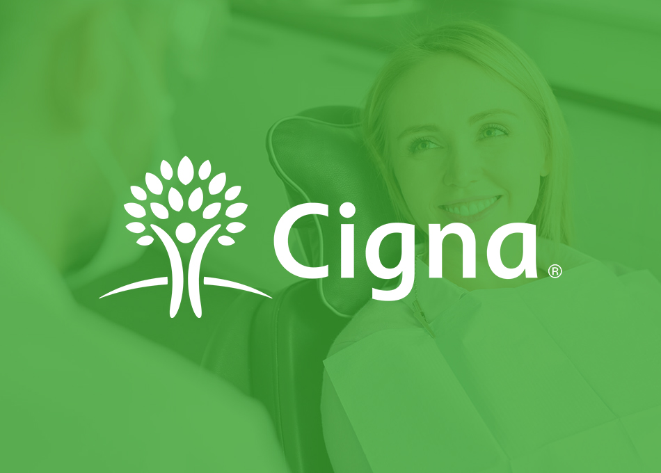 Cigna insurance logo with person in green-tinted healthcare professional setting background.