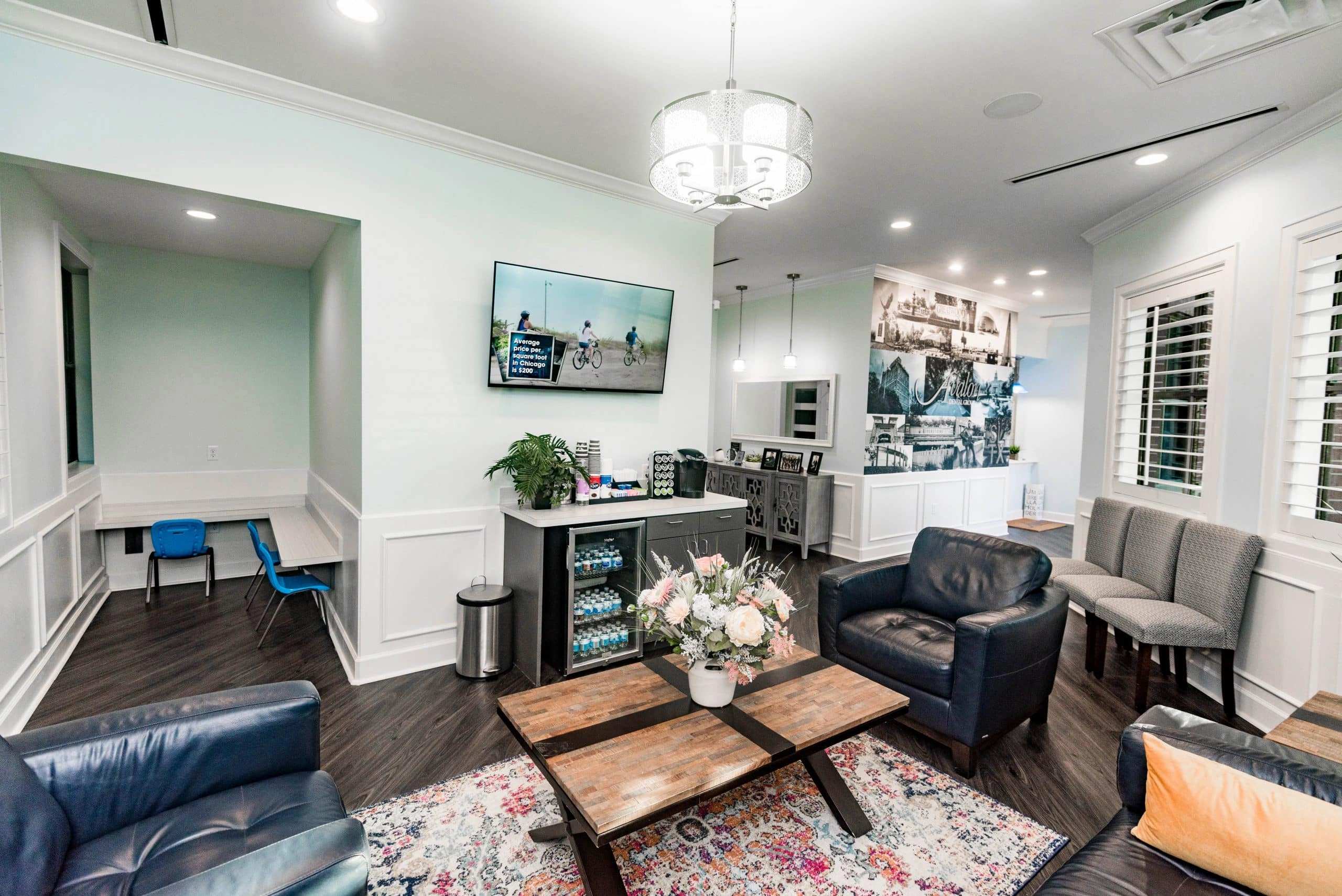 Modern dental office waiting room with comfortable seating, wooden table, and contemporary decor.