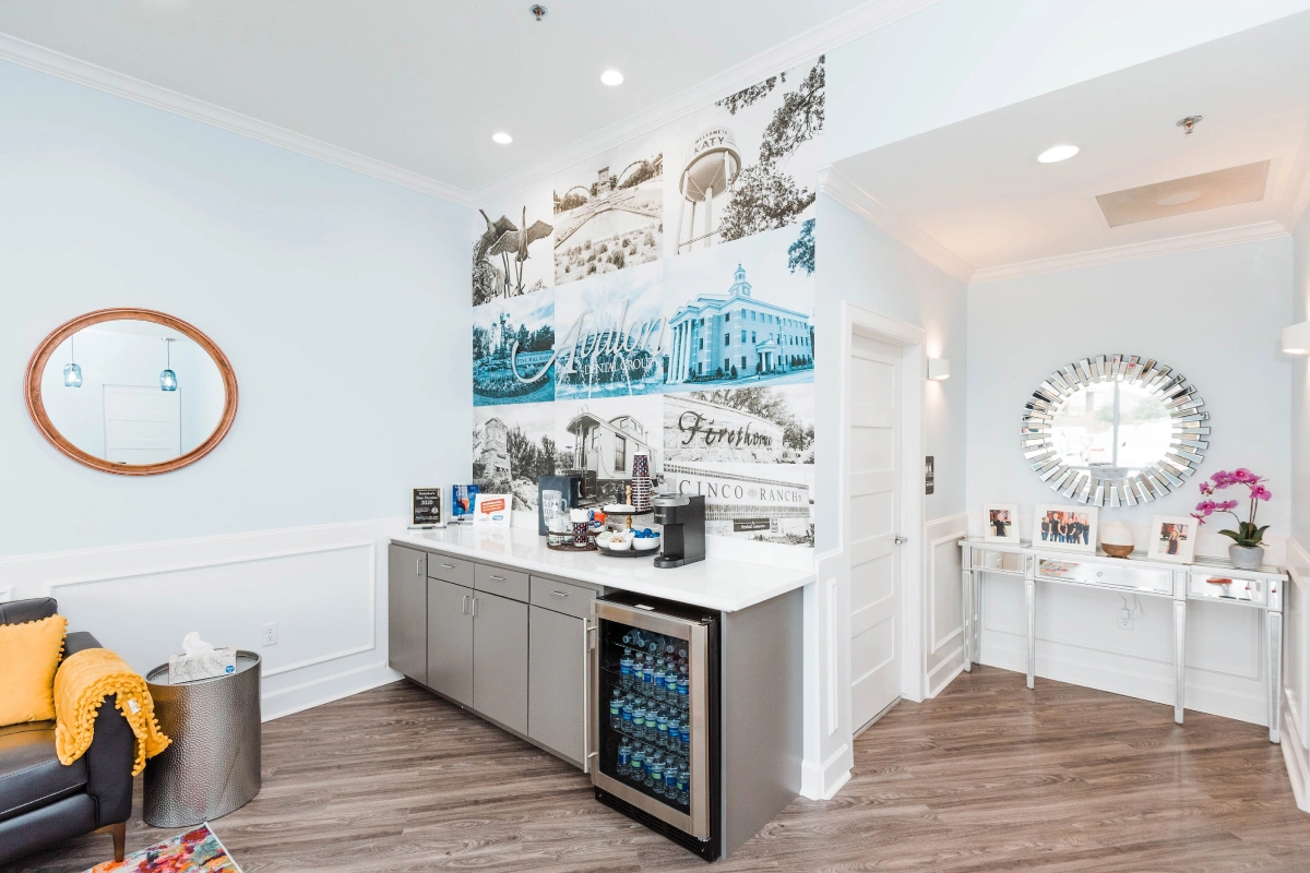 Modern dental office reception area with white cabinetry, blue artwork, and welcoming interior design.