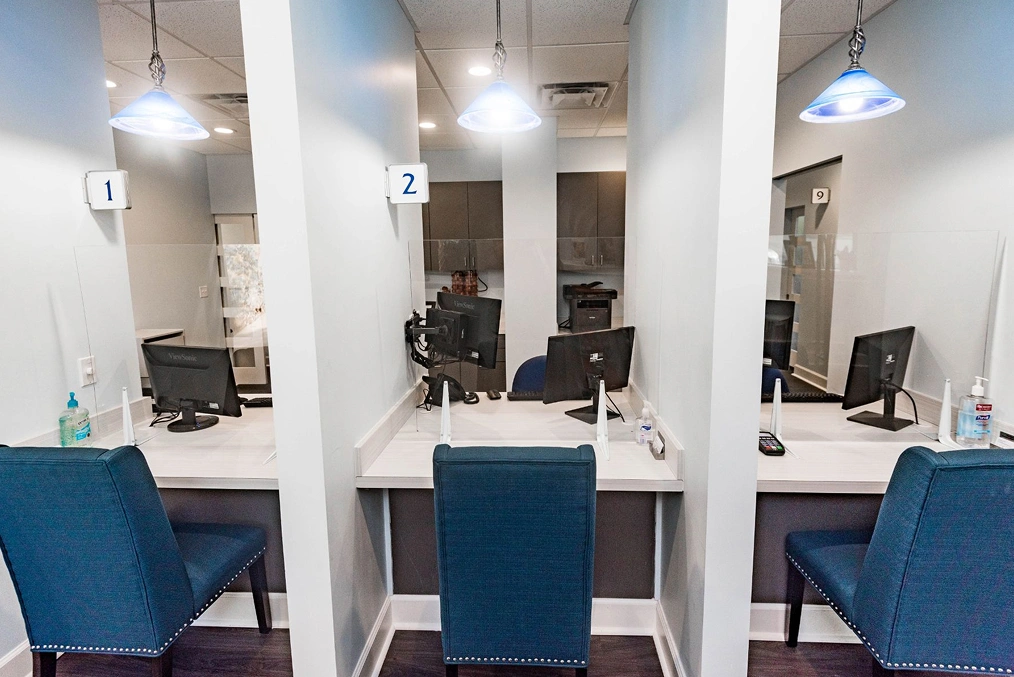 Modern dental operatories with blue chairs, mirrors, and professional equipment in clean clinical setting.