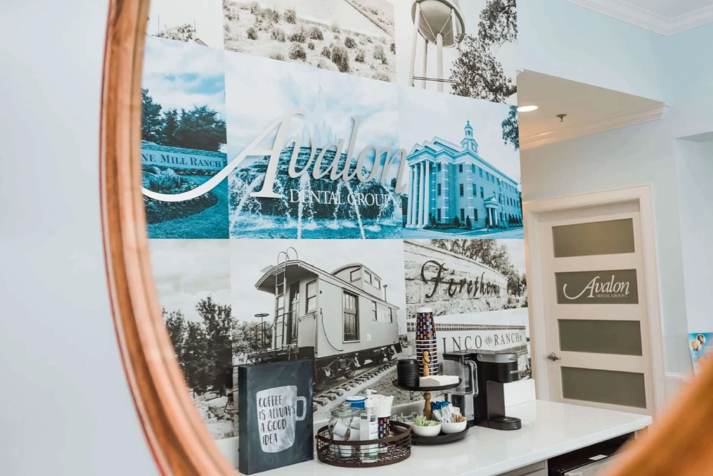 Dental office wall displays photos of beach scenes and practice interior with wooden frame accent.
