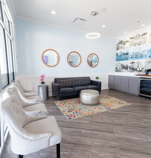 Modern dental office waiting room with comfortable seating, colorful artwork, and contemporary decor.