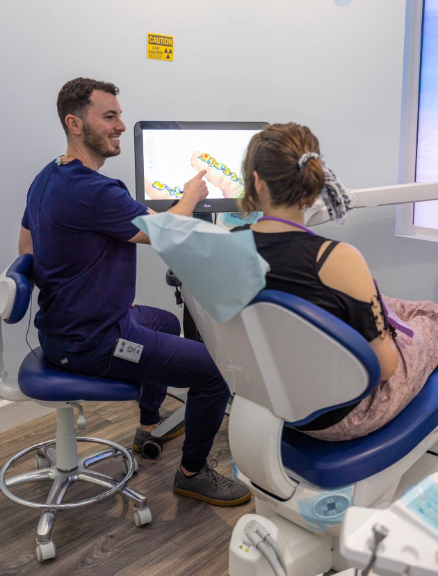Dental professional examining patient in clinical treatment chair at Avalon Dental Group office.