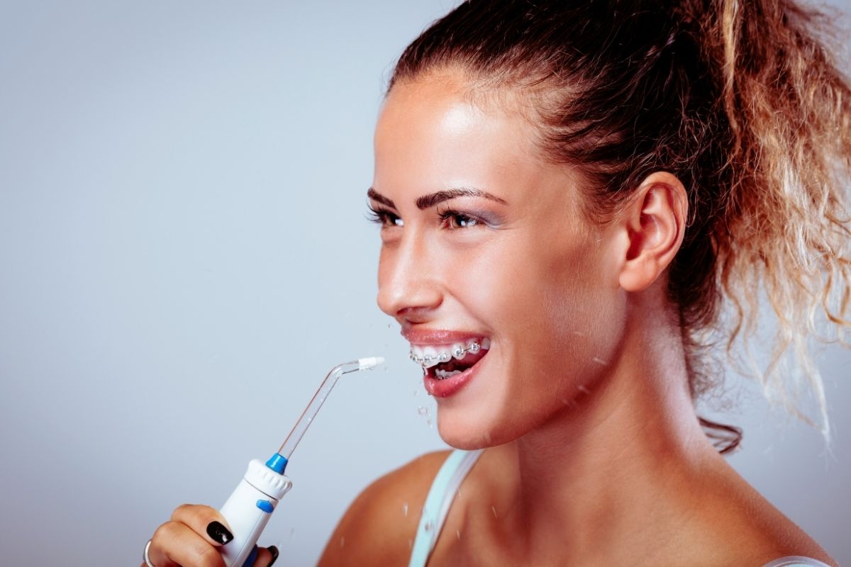 women wearing dental braces using water flosser