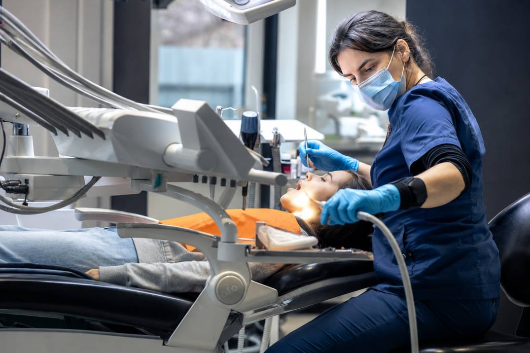 Dentist examining a patient with a tooth that feels higher when biting
